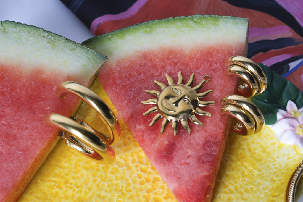 Primer plano de joyas artesanales sobre superficie neutra, con luz suave resaltando texturas y detalles.