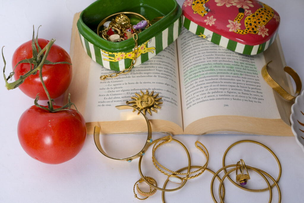 Primer plano de joyas artesanales sobre superficie neutra, con luz suave resaltando texturas y detalles.