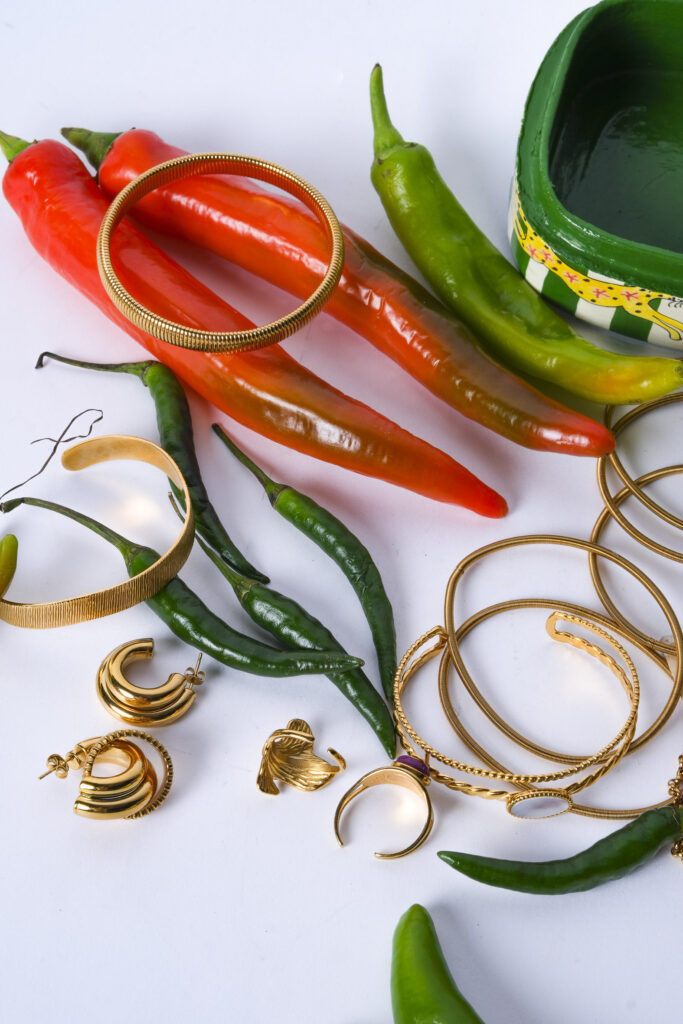 Primer plano de joyas artesanales sobre superficie neutra, con luz suave resaltando texturas y detalles.